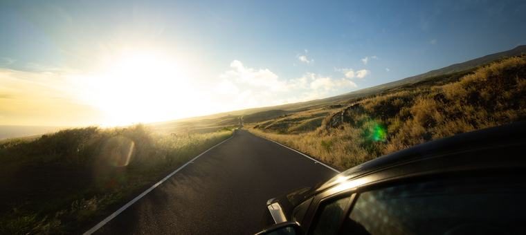 An open road stretching toward the horizon at sunrise
